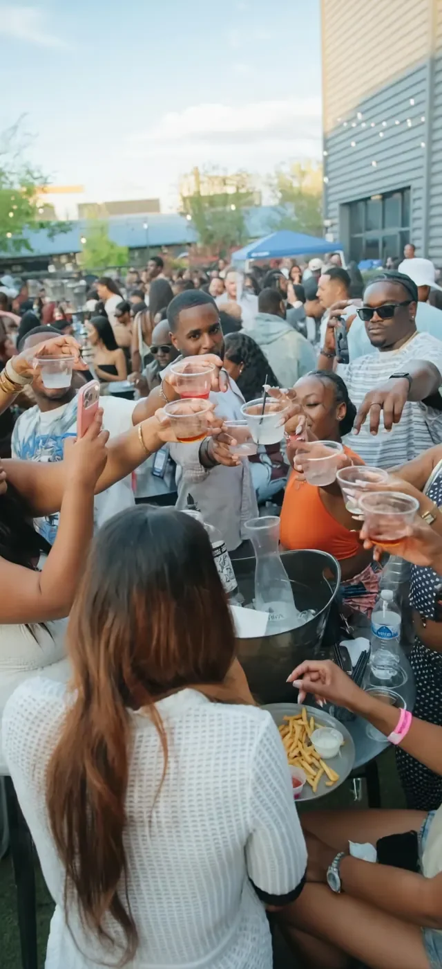 Guests raising their cups around an outdoor table